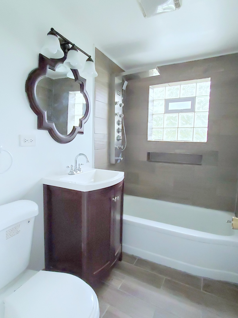 653 East 105th Street Chicago, IL 60628 - Photo 16 of 27 a bathroom with a sink toilet and shower