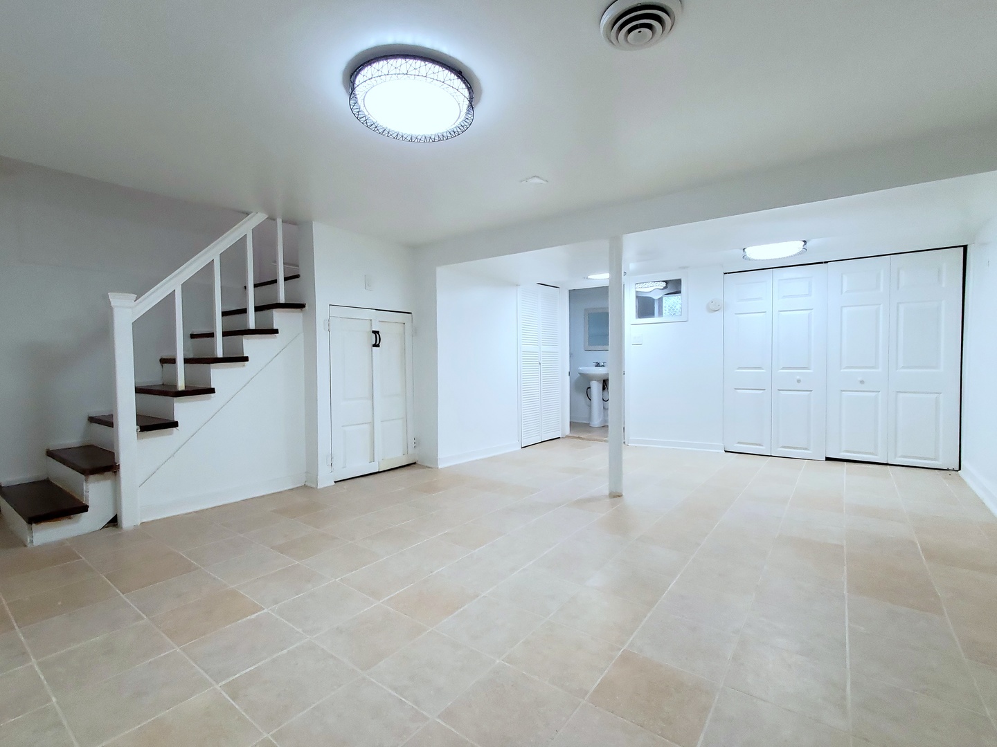 653 East 105th Street Chicago, IL 60628 - Photo 17 of 27 a view of an empty room with stairs and a ceiling fan