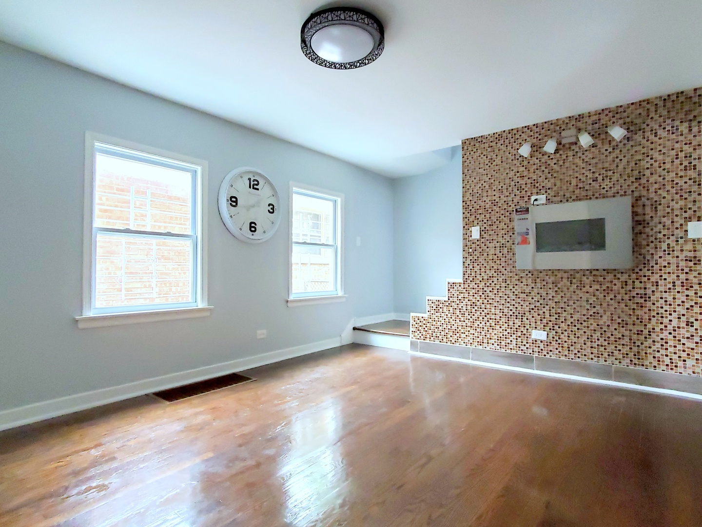 653 East 105th Street Chicago, IL 60628 - Photo 3 of 27 a view of an empty room with a window and wooden floor