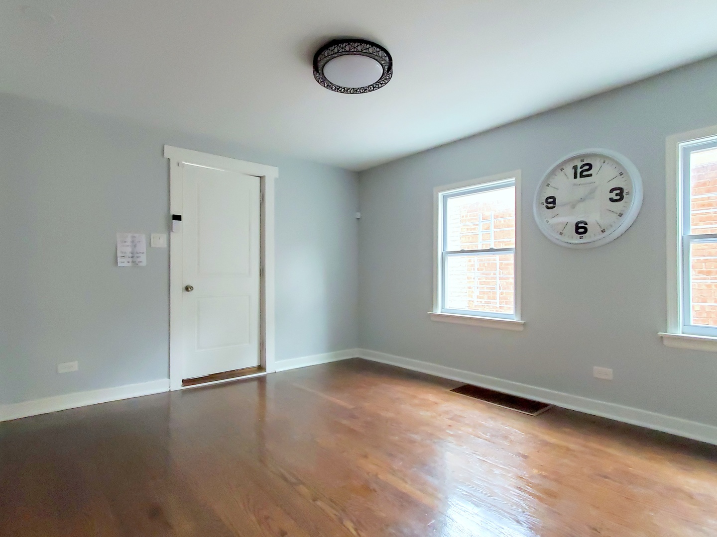 653 East 105th Street Chicago, IL 60628 - Photo 4 of 27 an empty room with a window and wooden floor