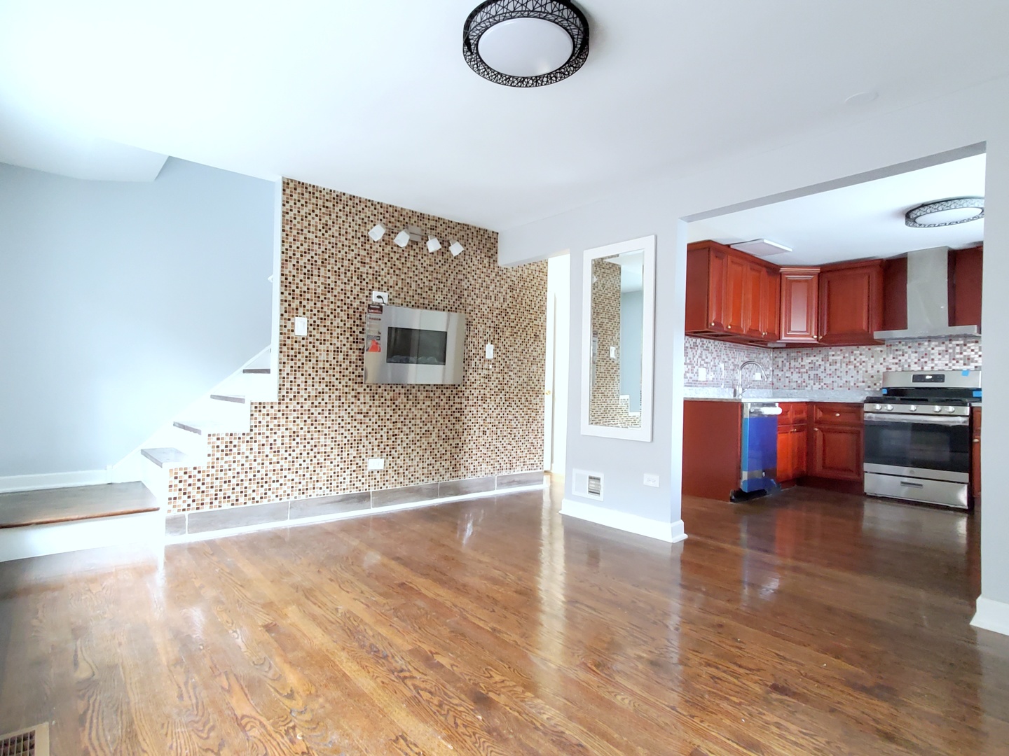 653 East 105th Street Chicago, IL 60628 - Photo 6 of 27 a living room with stainless steel appliances furniture a rug and a kitchen view