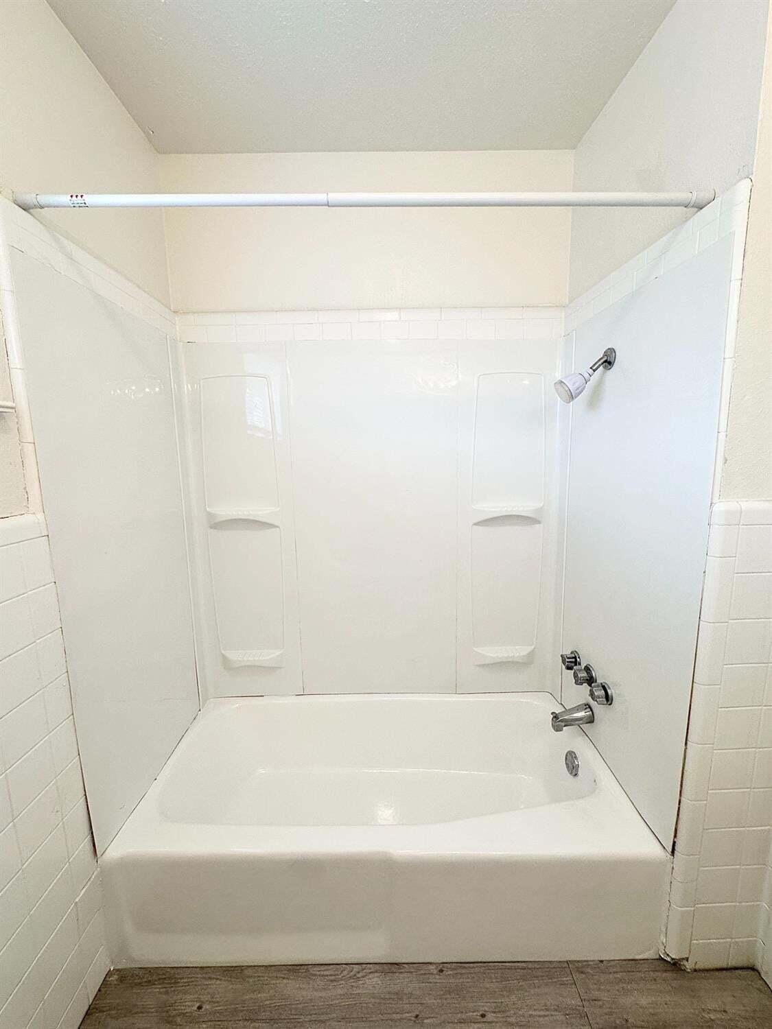 1303 65th Street Lubbock, TX 79412 - Photo 9 of 11 a bathroom with a shower and a bath tub