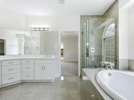 5034 West Fall Drive Midlothian, TX 76065 - Photo 24 of 40 Bathroom featuring a built-in soaking tub, a frameless glass shower enclosure, a dual vanity with white cabinetry and a light-toned countertop, multiple mirrors, and light tile flooring