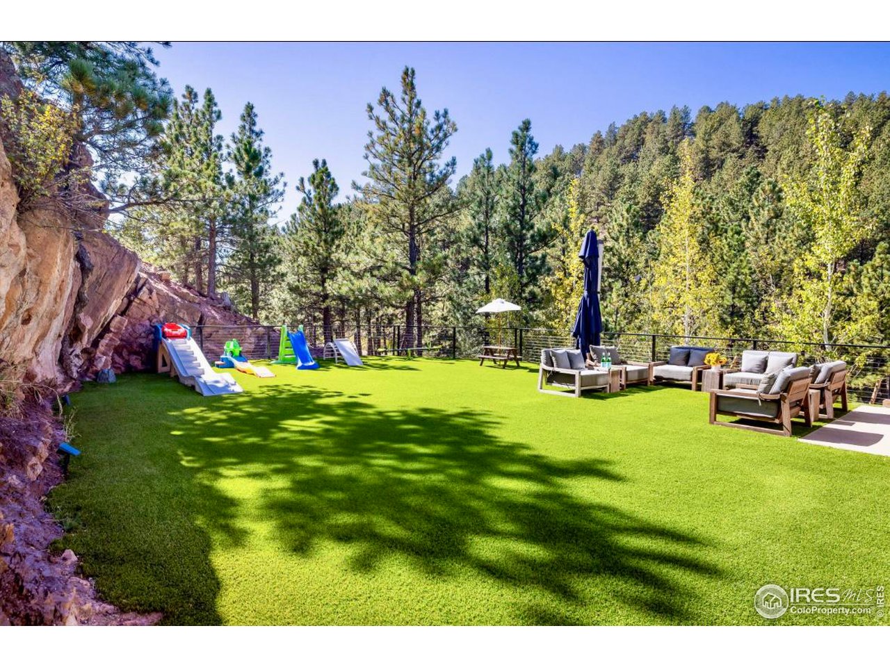 1151 Timber Lane Boulder, CO 80304 - Photo 13 of 33 A west-facing grassy, flat yard offers a quiet, sunlit retreat surrounded by native rock outcroppings, mature trees, and custom landscaping by Marpa