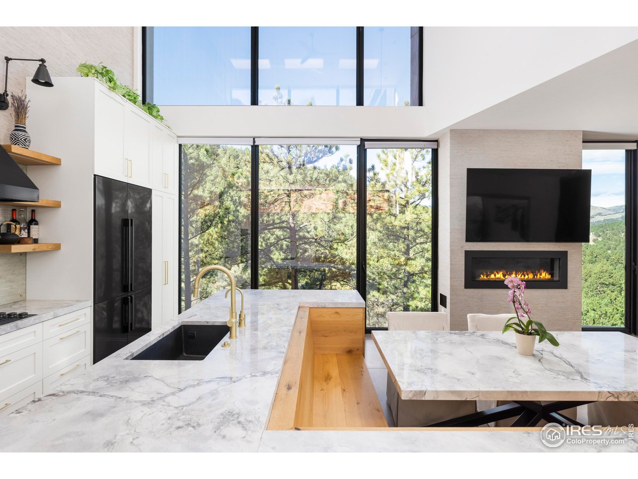 1151 Timber Lane Boulder, CO 80304 - Photo 17 of 33 Anchored by a sleek fireplace, the great room flows directly into the chef's kitchen, which features vaulted ceilings, luxury appliances, a striking marble island, and a cozy breakfast nook that connects seamlessly to the dining area.