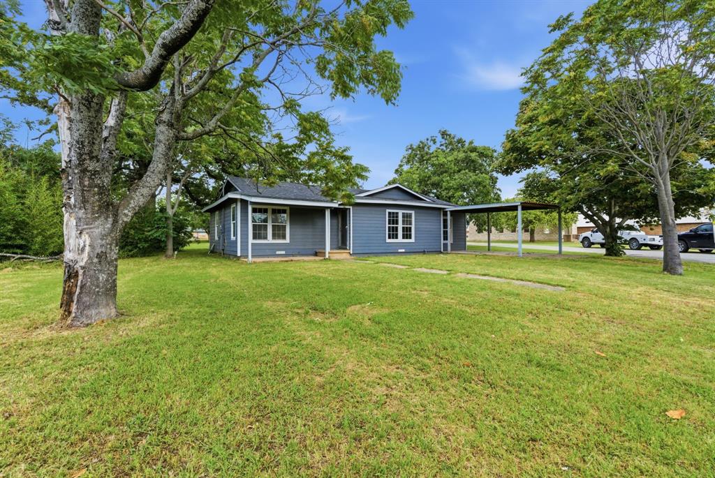 203 North Kickapoo Street Lipan, TX 76462 - Photo 1 of 28 a front view of a house with garden