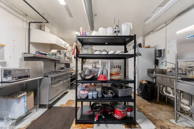 a kitchen with lots of wooden furniture and appliances