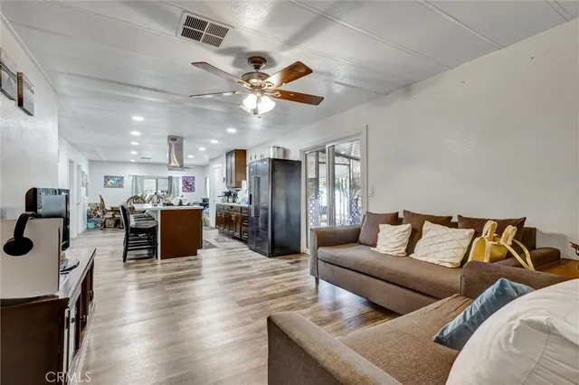 a living room with furniture kitchen view and a chandelier