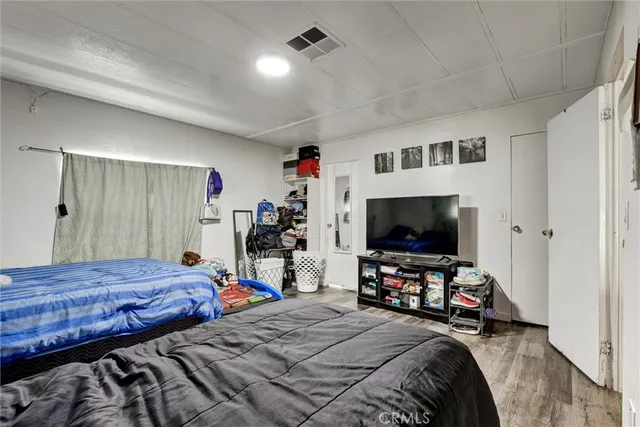 a bedroom with bed tv and a window