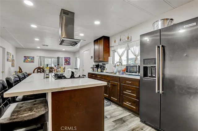 a kitchen with kitchen island granite countertop a sink stainless steel appliances and cabinets