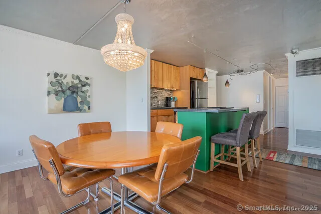 a dining room with furniture a chandelier and wooden floor