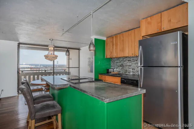a kitchen with a refrigerator a stove and a dining table with wooden floor