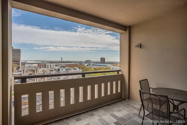 a view of a balcony with wooden chairs