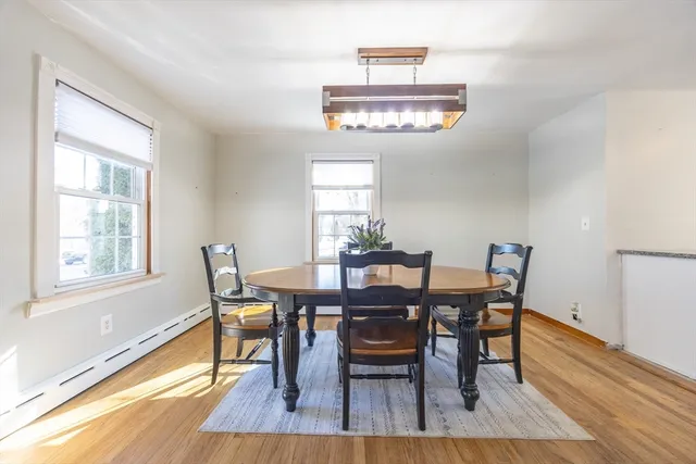 a view of a dining room with furniture a chandelier and wooden floor