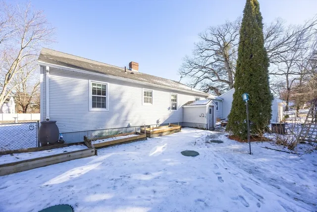 a view of a white house with a yard covered in snow