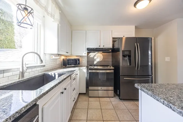 a kitchen with a refrigerator sink and cabinets