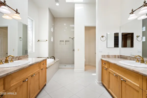 a spacious bathroom with a double vanity sink mirror double and shower