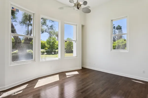 a view of an empty room with a window and wooden floor