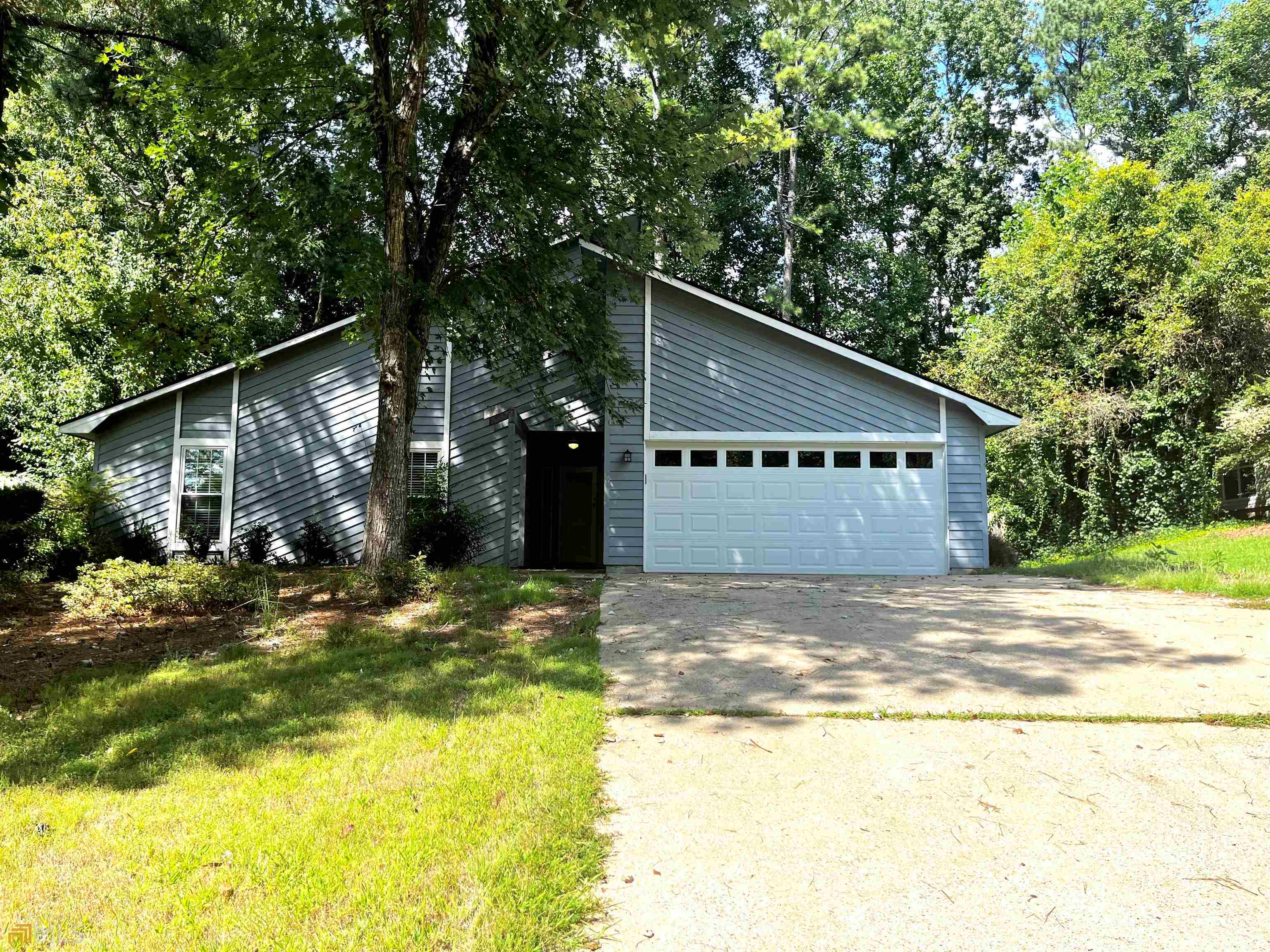 a view of a house with backyard and trees