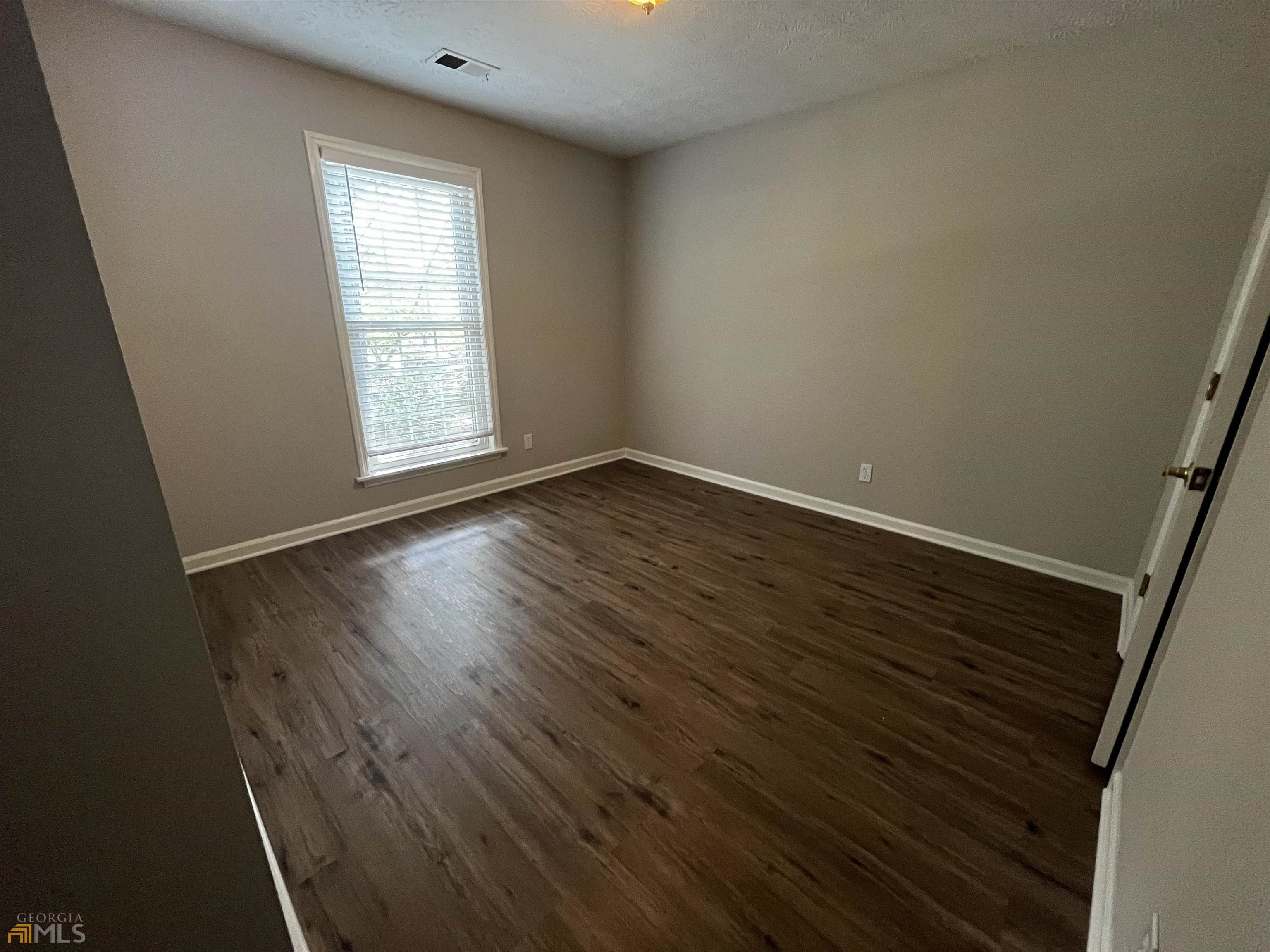 320 Broken Lance Place Alpharetta, GA 30022 - Photo 15 of 18 an empty room with wooden floor and windows