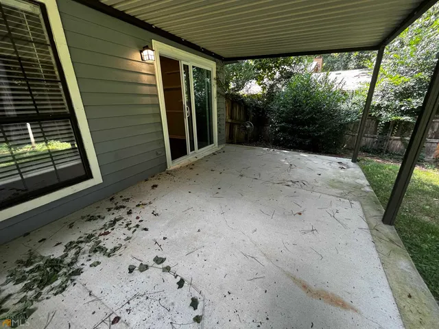 a view of a backyard with floor to ceiling window and tree