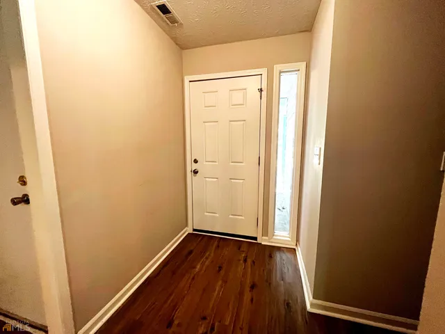 an empty room with wooden floor and closet