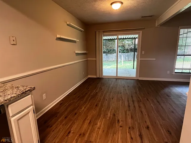 a view of a room with wooden floor and electronic appliances