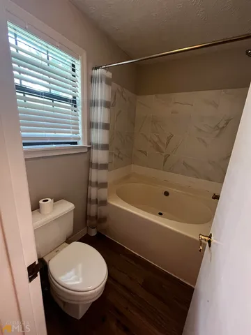 a bathroom with a sink a toilet a mirror and shower