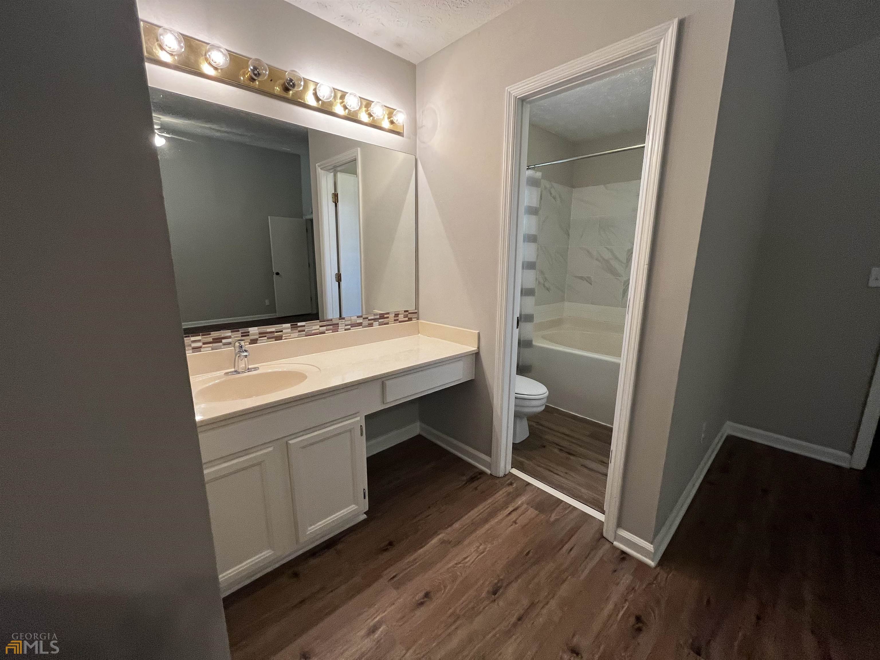 320 Broken Lance Place Alpharetta, GA 30022 - Photo 10 of 18 a bathroom with a sink a mirror and a shower