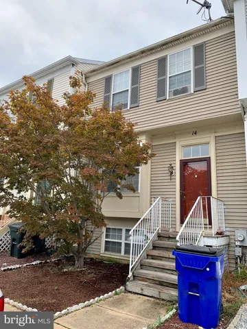 a view of a brick house with a small yard and plants