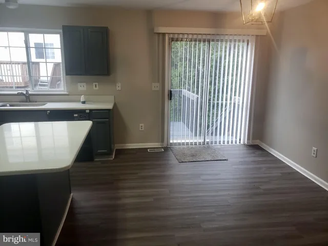 a view of a kitchen with wooden floor and a window