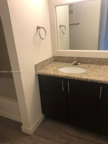 a bathroom with a granite countertop sink and a mirror