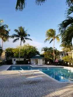 a palm tree sitting in front of a house with a yard
