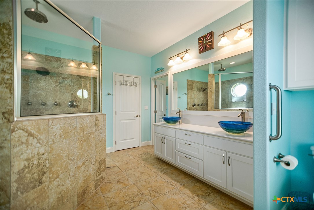 23 Macey Street Port O'Connor, TX 77982 - Photo 34 of 47 a bathroom with a granite countertop sink and a mirror
