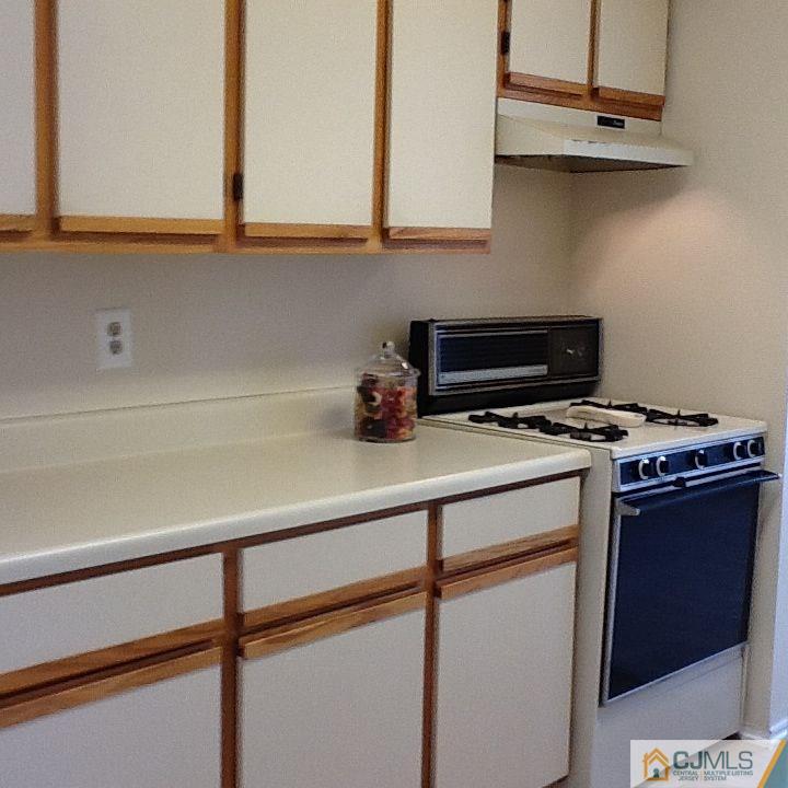 32 Boulder Drive, Unit 32 Edison, NJ 08817 - Photo 6 of 24 a kitchen with a cabinets and a stove top oven