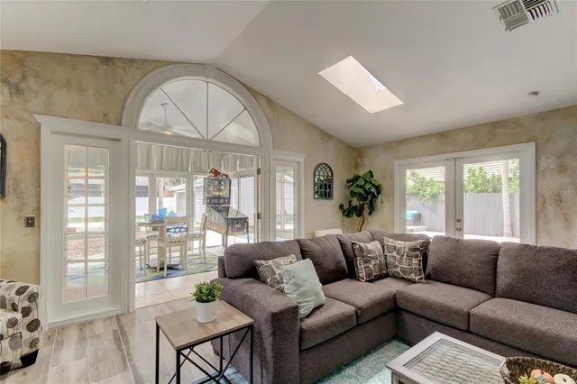 a living room with furniture a large window and a chandelier