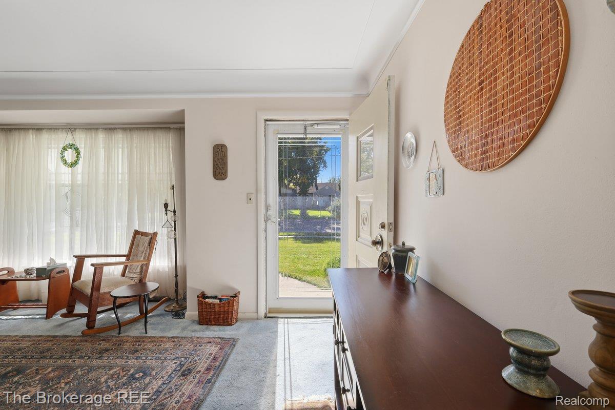 613 East Atherton Road Flint, MI 48507 - Photo 8 of 42 Entryway featuring a solid door with a sidelight, a spacious window, and carpet flooring