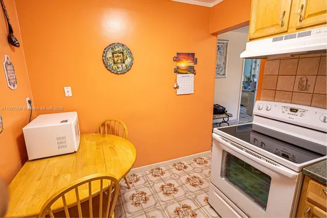 a kitchen with stainless steel appliances granite countertop a stove a refrigerator and a dining table