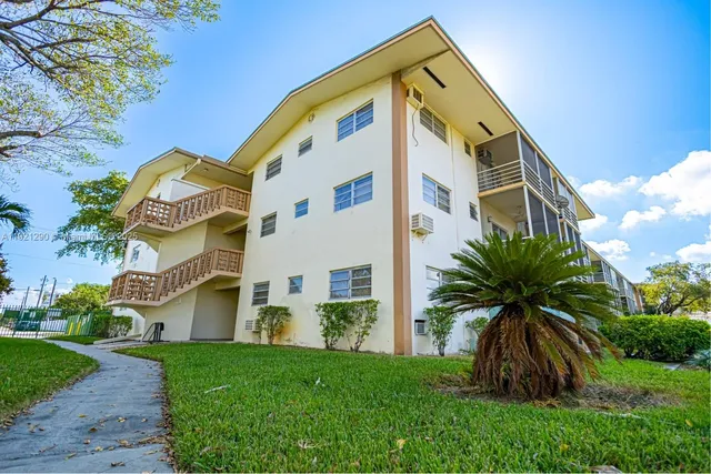 a view of a hallway with wooden floor and a bathroom