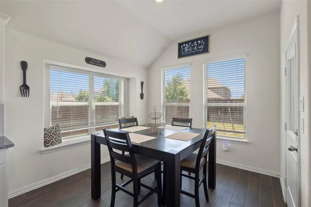 a view of a dining room with a table and chairs