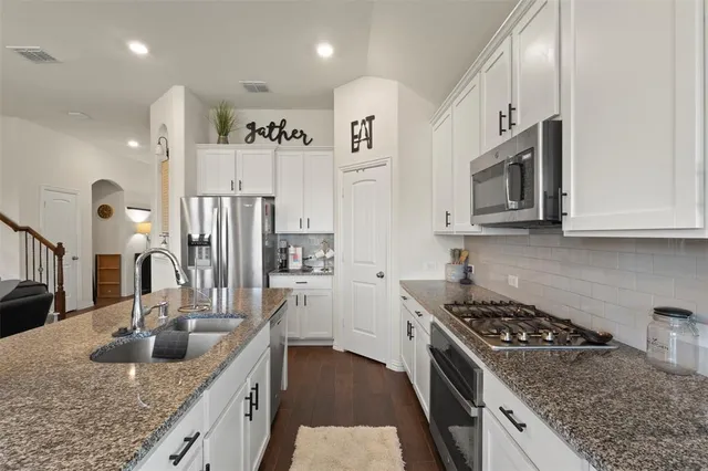 a kitchen with stainless steel appliances granite countertop a sink stove and cabinets