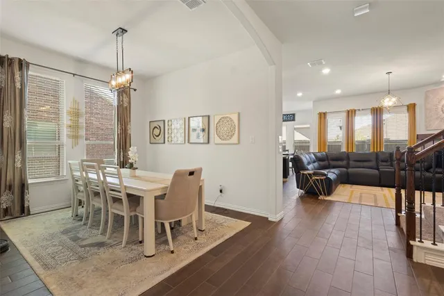 a dining room with furniture a chandelier and wooden floor