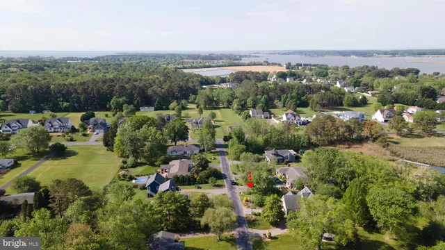 an aerial view of a houses with a yard and lake view