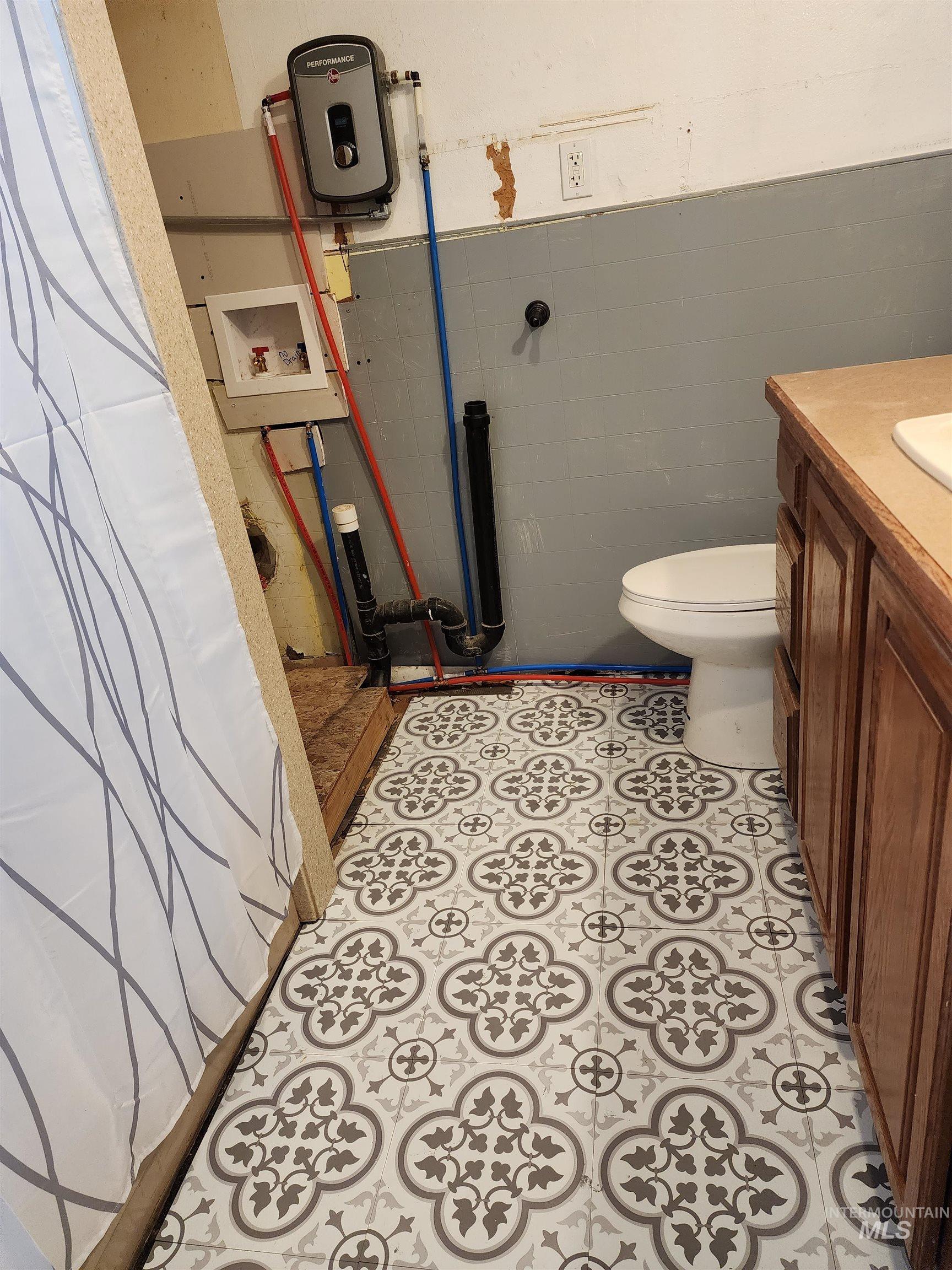 188 Morton Street West Vale, OR 97918 - Photo 5 of 9 Bathroom featuring vanity, tile walls, and a wainscoted wall