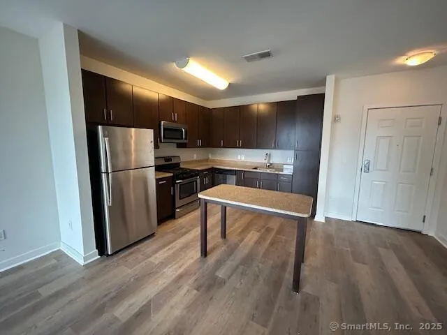 a kitchen with wooden floors and stainless steel appliances