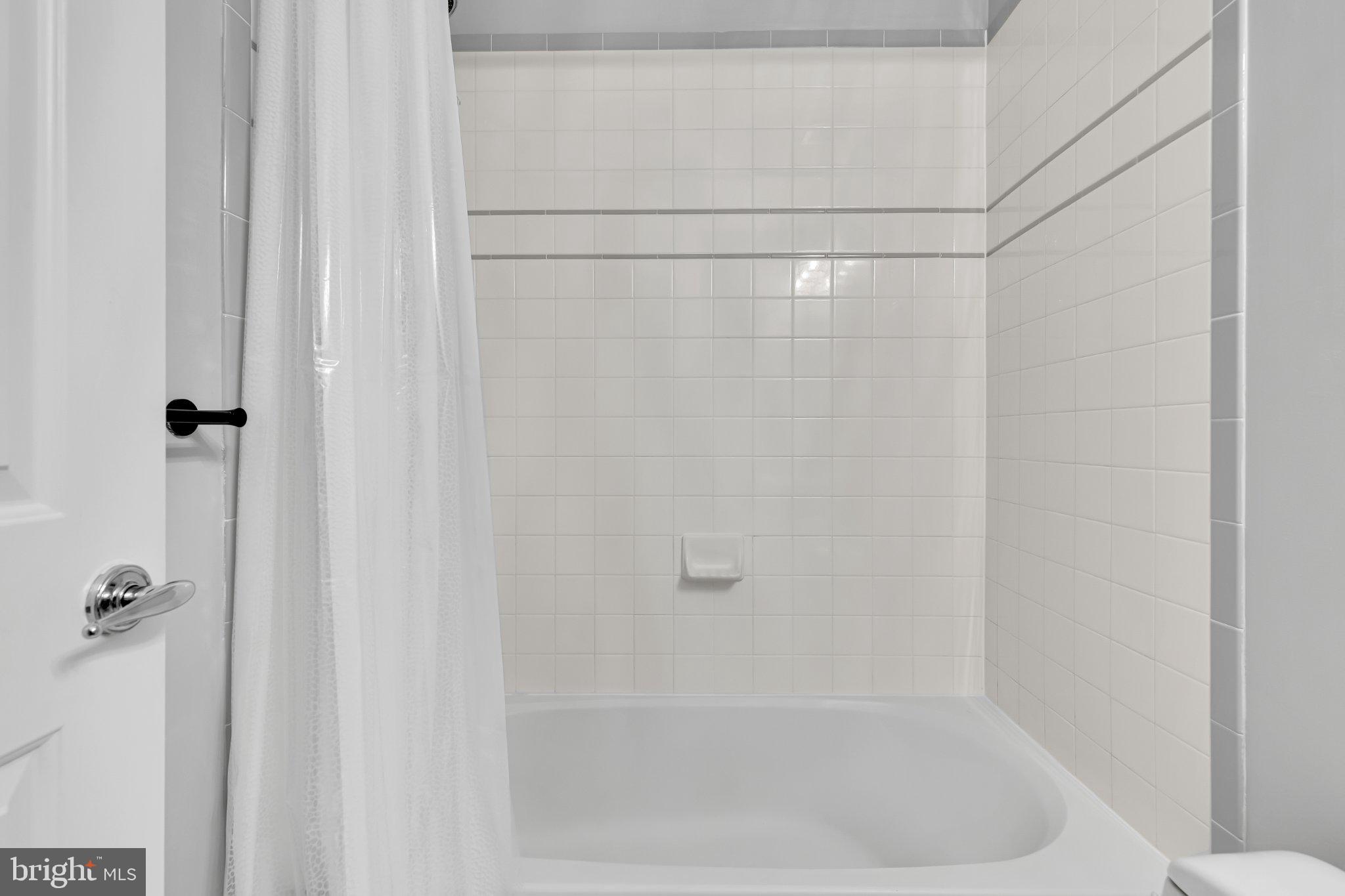 2201 K Street Northwest, Unit 4 Washington, DC 20037 - Photo 13 of 22 Serene white-tiled bathroom retreat.