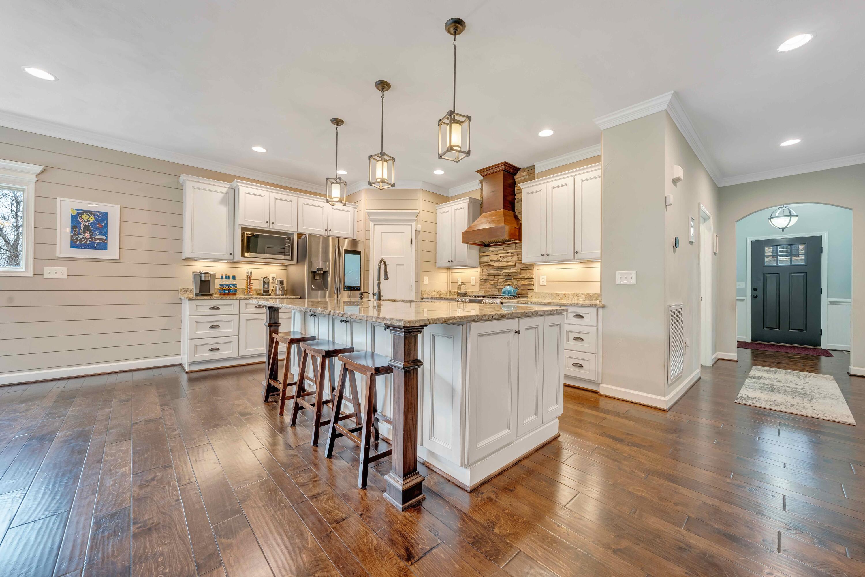 7041 Mountain Spring Trail Roanoke, VA 24018 - Photo 20 of 62 a kitchen with stainless steel appliances kitchen island granite countertop wooden floors and cabinets