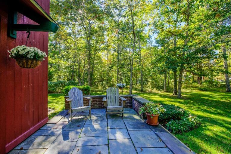 334 Old Oyster Road Cotuit, MA 02635 - Photo 9 of 17 a view of a patio with table and chairs potted plants and large tree