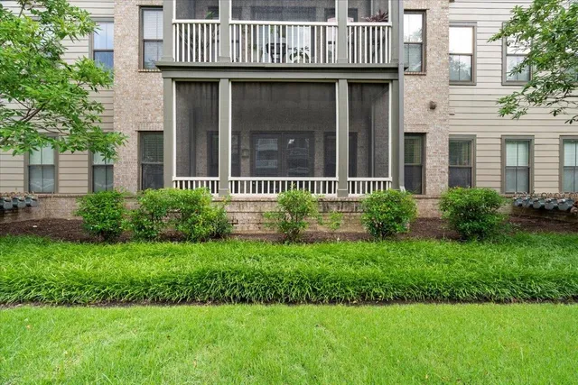a view of a brick house with a yard and plants