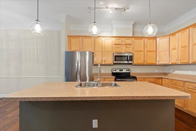 a kitchen with stainless steel appliances a sink a stove and a refrigerator